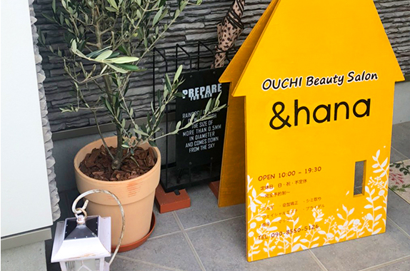 ＆hanaの入口に置かれた黄色い家形の看板